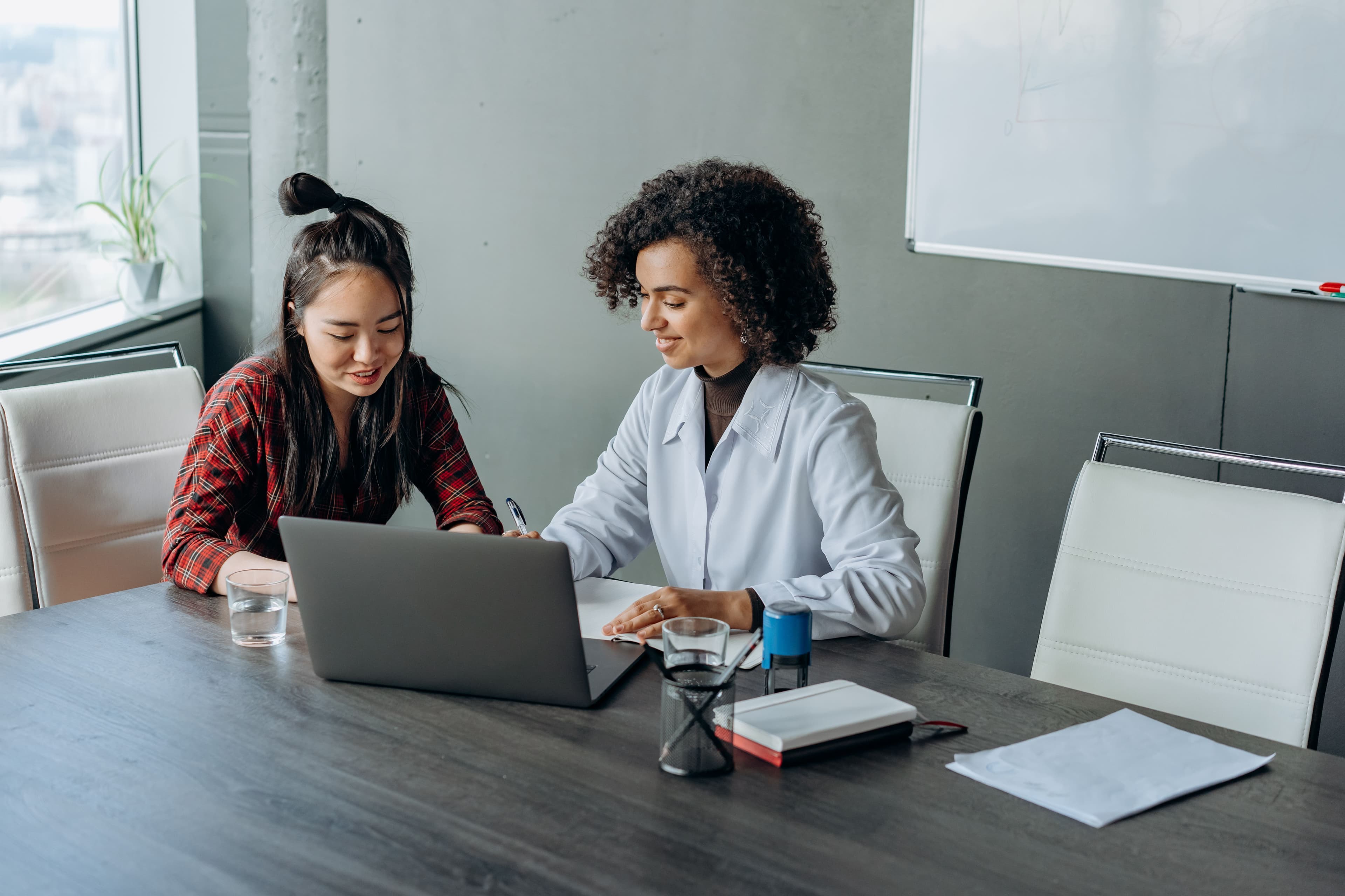 Two writers reviewing work together on a laptop